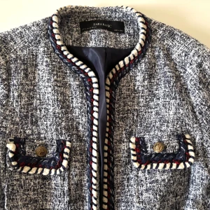 Mönstrad jacka från Zara Basic - Klassisk prêt-à-porter kavaj / jacket, fina dekorativa detaljer. Passar bra till office wear eller casual jeans. Ett mönstrat tyg med blå, vita och röda detaljer. Jackan har långa ärmar och dekorativa knappar på fickorna. Perfekt för att ge din outfit en stilfull touch.