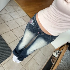 crazy age jeans - jättefina lågmidjade jeans från crazy age med rosa detaljer. innerbenslängden är 81cm och midjemåttet är 38cm. köpte på plick men säljer eftersom jag köpte några liknande som jag gillade mer. liten defekt som syns på sista bilden, syns ej när man har på sig dom och känns ingenting.🩷 