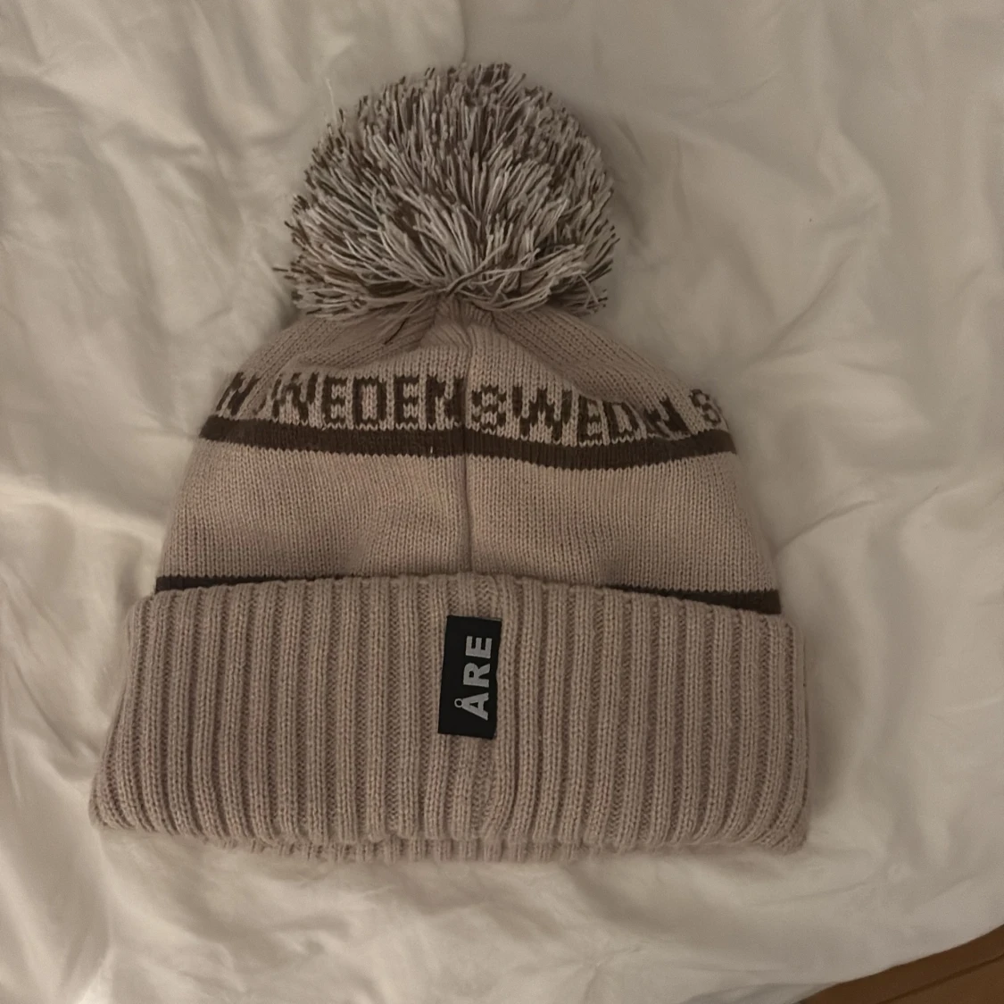 Beige mössa med tofs från Åre  - 1