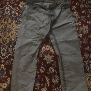 Grå jeans från Levi's 501 - Snygga grå jeans från Levi's med klassisk design. De har en rak passform och är perfekta för en avslappnad stil. Märkeslappen på baksidan ger en autentisk stil, w34 L 30