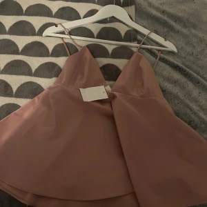 Rosa fest topp - Säljer en söt rosa topp med smala axelband och v-ringad design. Perfekt för sommarens alla tillfällen. Toppen har en luftig passform och är tillverkad i ett mjukt material som ger en skön känsla. Även perfekt för fester! Fråga gärna om fler bilder