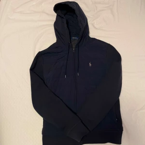 Polo Ralph Lauren Cardigan - Extremt bra skick 9/10, inga deffekter. Kvitto finns. Endast använd ett fåtal gånger. Storlek M. QR skann som tar dig till deras hemsida. Nypris ligger på ungefär 3300kr..  Kontakta för mer info. 