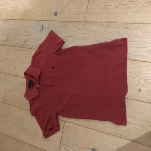 Rosa pikétröja från Ralph Lauren - Säljer en snygg rosa pikétröja från Ralph Lauren med klassisk krage och knappslå. Tröjan har en liten broderad logotyp på bröstet och korta ärmar. Perfekt för en stilren look! Jag är 171 lång så jag rekommenderar att ha den om man är 160-165 cm efter som att den sitter rätt tajt på mig. Perfekt inför sommaren