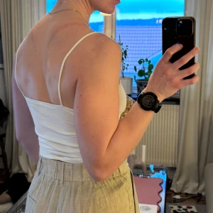 Vit linne från Gina Tricot - Säljer ett vitt linne från Gina Tricot. Toppen har smala axelband och en tight passform, säljs då jag har två likadana. Materialet är mjukt och bekvämt. Några sömmar på insidan som blivit lite fula men syns ej när man har på sig!