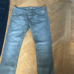 Grå jeansbyxor från Replay - Snygga grå jeansbyxor från Replay  med en klassisk femficksdesign. Byxorna har en rak passform och är tillverkade i slitstarkt denim. Perfekta för en avslappnad stil.