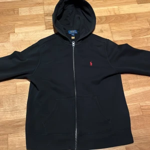 Svart hoodie från Polo Ralph Lauren - Säljer min svarta Ralph Lauren hoodie då den är för liten. Perfekt nu till våren. Inga skador bara använd. skick 9/10. Storlek 14-16 år (L). Pris inte fast. Skicka om minsta fråga👍