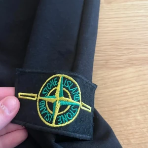 Svarta shorts från Stone Island - Snygga svarta shorts från Stone Island med elastisk midja och det ikoniska märket på sidan. Perfekta för en avslappnad stil.
