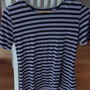 Randig tröja  - Skiiitcool randig tshirt i svart o lila. Köpt second hand