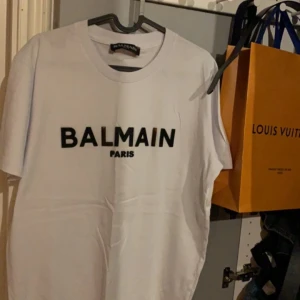 Vit t-shirt från Balmain - Säljer en stilren vit t-shirt från Balmain. Såklart äkta, säljer för att den inte passar på mig längre, skriv om ni har några frågor eller vill ha mer bilder :)