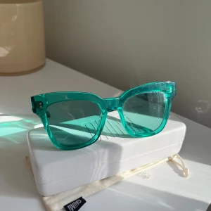 Turkosa glasögon från Chimi 005 Aqua - Snygga turkosa glasögon från Chimi med en fyrkantig form. De har en transparent look som ger en modern. Kommer med ett vitt fodral för säker förvaring. #005 Aqua