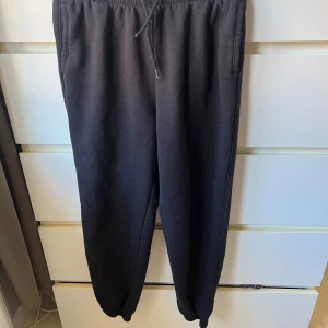 Svarta mjukisbyxor från H&M Divided - Säljer ett par svarta mjukisbyxor från H&M Divided. Byxorna har en elastisk midja med snörning för justerbar passform 🌸 Knappt använda!