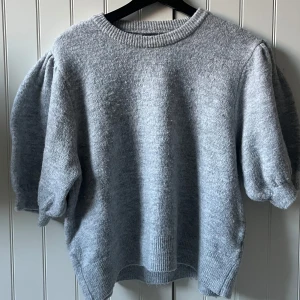 Grå stickad tröja från Gina Tricot - Säljer en mysig grå stickad tröja från Gina Tricot i storlek XL💓Tröjan har puffiga ärmar och ribbade kanter! Perfekt för kyliga dagar! Den är i bra skick! Skriv om du har frågor💞