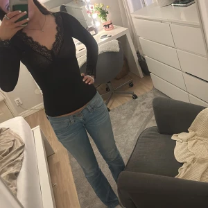 Svart långärmad topp med spetsdetaljer - Snygg svart långärmad topp från intimissimi med v-ringad spetsdetalj. 