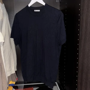 Mörkblå t-shirt från Zara - Säljer en klassisk mörkblå t-shirt från Zara. Den har en enkel design med rund hals och korta ribbade ärmar, perfekt för en stilren look. Inga tecken på användning, skriv vid funderingar eller annat