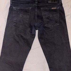 Nudie jeans 30/32 - Snygga svarta jeansbyxor från Nudie jeans med klassisk femficksdesign. Byxorna har en normal passform och är tillverkade i ett slitstarkt denimtyg. Perfekta för en stilren look.