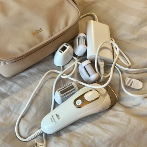 Braun Silk-expert Pro 5 IPL - Säljer en Braun Silk-expert Pro 5 IPL med flera tillbehör och en praktisk förvaringsväska. Perfekt för effektiv permanent hårborttagning hemma. Enheten är vit med guldiga detaljer och kommer med olika huvuden för anpassad användning. Köpt på Elgiganten för ordinariepris 6000 kr. 