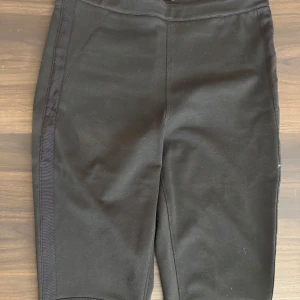 Svarta byxor från Calvin Klein - Snygga svarta byxor från Calvin Klein i en tight passform. Byxorna har en stilren design med diskreta bakfickor och är tillverkade i ett mjukt material för extra komfort.