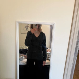 Mörkgrå stickad tröja från ONLY - Säljer en mysig mörkgrå stickad tröja från ONLY. Tröjan har en v-ringad hals och långa ärmar, perfekt för kyligare dagar. Den är både stilren och bekväm, idealisk för en avslappnad look. Använd max 2 gånger.