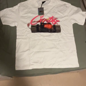 Cortiez t shit  - Säljer en vit t-shirt från Authentic med ett coolt tryck av en digital timer och graffiti på framsidan. Baksidan har texten 'NO TIME 4 LUV' i svart. Perfekt för en avslappnad stil.