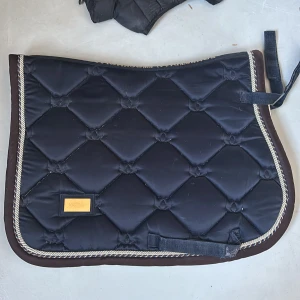 EQUESTRIAN STOCKHOLM schabrak strl cob  - Säljer detta EQUESTRIAN STOCKHOLM schabraket i strl cob. Mycket bra skick. Mörkblått med brun ytterkant och brun,blå och silver kant ! Tvättas innan köp!