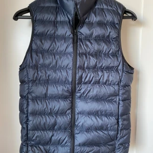 Blå dunväst från Uniqlo -  Tjenare, jag säljer en snygg blå dunväst. Perfekt nu för vår/sommar. Den är i strl xs. Hör av dig vid någon fundering👑