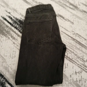 Svarta jeans från Levis - Snygga svarta jeans från Levis med klassisk femficksdesign och knappgylf. Perfekta för en stilren look. Passar till det mesta och är ett måste i garderoben.