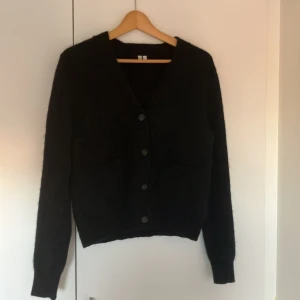 Mörkblå ullkofta ARKET - Mörkblå v-ringad kofta med knappar från Arket. (32% alpacka, 32% ull, 30 % polyester, 5 % elastan) 