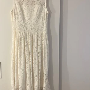 Vit spetsklänning från Vintage Stories - Elegant vit spetsklänning från Vintage Stories med ärmlös design och vackert spetsmönster. Perfekt för student, skolavslutning eller sommaren!! Använd max 3 gånger💕