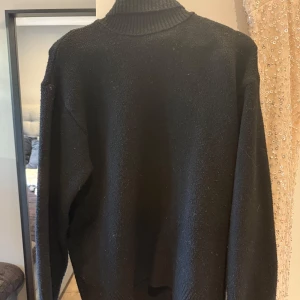 Svart polotröja  - Svart polotröja med ribbad hög krage och långa ärmar. Tröjan är stickad i mjukt material. Perfekt för dig som gillar stilrena och klassiska plagg med exklusiv känsla. Skriv för fler bilder💕