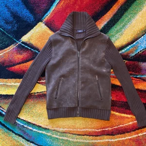 Unik Stickad Mexx cardigan med äkta brunt mocka perfekt skick  - Snygg brun jacka från Mexx med stickade ärmar och krage. Framsidan är i äkta mocka och har två dragkedjeförsedda fickor. Jackan har hel dragkedja framtill och ribbade detaljer på ärmar, krage och nederkant. Perfekt för dig som gillar en chill och stilren look .storlek är M men passar även M väldigt svår att hitta väldigt sällsynt!! Skicket är som nytt 10/10 DM för fler bilder eller frågor 🦥🦬👞🍂