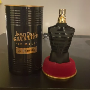 Jean Paul Gaultier Le Male Parfym 60/75ml - Säljer en Jean Paul Gaultier Le Male Le Parfum. Flaskan har en unik design i form av en svart matt torso med gulddetaljer på sprayhuvudet. Kommer i en svart metallburk med guldtext och röd sammetsbas. En ikonisk och stilren herrdoft. Ungefär 60ml kvar av 75ml