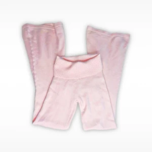Ljusrosa stickade byxor från Edikted - Supermjuka ljusrosa stickade byxor från Edikted med bred ribbad midja. Byxorna har raka ben och är perfekta för en chill och cozy look. Materialet är stickat och känns riktigt skönt mot huden.