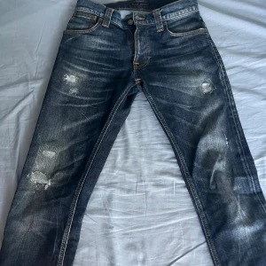 Nudie Grim Tim Jeans med slitningar - Halloj! Säljer nu ett par nudie jeans med riktigt skön tvätt och schyssta slitningar! Org storleken är 29/34 men är uppklippta så sitter mer som 29/32 eller 29/30. Skriv vid minsta fundering! Pris kan diskuteras!