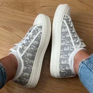 Christian Dior sneakers - Säljer mina extremt snygga sneakers från Christian Dior med grått och vitt monogrammönster. Tjock vit sula med Dior-logga på sidan och tå. Självfallet äkta och dustbag, box inkommer. Hade kunnat tänka mig byta mot ett par svarta eller mörkblå dior skor! Pris kan diskuteras.
