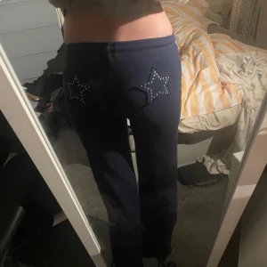 Mörkblå mjukisbyxor med stjärnor Bershka - Mörkblå mjukisbyxor från Bershka i storlek XS. Byxorna har bootcut-modell och är dekorerade med två stjärnor i strass på bakfickorna. Perfekta för en chill och trendig look.