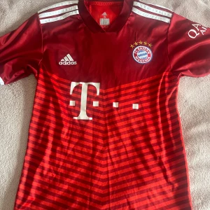 Bayern München Lewandowski tröja⚽️ - Säljer en officiell FC Bayern München matchtröja från Adidas med Lewandowski #9 på ryggen. Tröjan är röd med mörkröda och ljusröda horisontella ränder, vita detaljer och klubbmärke på bröstet. Materialet är lätt och andas, perfekt för fotboll eller häng med polarna. Köpt i Tyskland 🇩🇪 (Munich) 