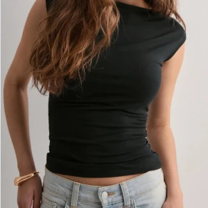 Svart rygglös topp från Gina tricot  - Snygg svart croppad topp med korta ärmar och tight passform från Ginatricot. Toppen är rygglös. I mycket bra skick! ☺️💕 Strl S/ Xs