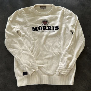 Vit stickad tröja från Morris - Snygg vit stickad tröja från Morris med broderad logga och brittisk flagga på bröstet. Pris kan diskuteras!! ✅