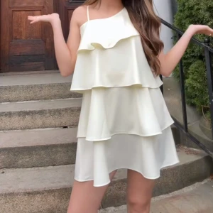 Ljusgul omlottklänning med volanger - Supersöt ljusgul kortklänning med flera lager volanger och asymmetrisk axel. Klänningen har ett tunt axelband och är tillverkad i ett lätt, flödande material som ger en luftig känsla. Perfekt för både vardag och fest! På bilden är det den vita men jag säljer den gula/ljusgula!! Endast använd en gång. Säljer då min garderob är alldeles för full. Den är i storlek 170 så typ S. PRIS GÅR ATT DISKUTERA!!💛💛