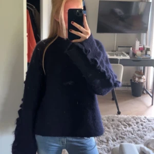 Mörkblå oversized stickad tröja - Säljer en mörkblå oversized mohair tröja med långa ärmar och volqnger längs ärmarna. Så fin och mysig. Från arket, nypris 990