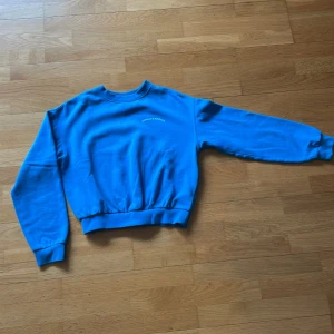 Blå sweatshirt från H&M XS - Blå sweatshirt från H&M i storlek XS. Tröjan har rund hals, långa ärmar och resår vid midja och ärmslut. På bröstet står det 'INHALE & EXHALE' i vitt. Perfekt för en chill och avslappnad stil.