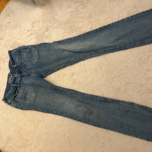 Blå bootcut jeans från ONLY, 30/32 - Snygga blå jeans från ONLY i klassisk bootcut-modell. Jeansen har fem fickor, bälteshällor och en lätt tvättad look. Tillverkade i mjukt denimtyg som sitter skönt och passar perfekt till sneakers eller boots. De är insydda så skulle säga att de är mer 28/32 i storlek! De är ca 82cm i innerbenslängden och uppsprättade där nere! 🥰