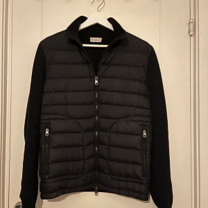 Svart Moncler Cardigan - Hej, jag säljer min Moncler cardigan i färgen svart. Den är i väldigt bra skick, passar bra till allt! Klicka på ”köp nu” ifall du vill köpa den, har du några frågor så skicka gärna ett DM!