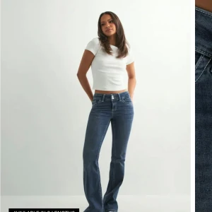 Mörkblå bootcut jeans med dubbla knappar - Trendiga jeans från Nelly!! Jätte snygga  stitch jeans från Nelly. Jätte fint skick (inga defekter) och är verkligen jätte sköna på. 
