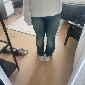 Blå bootcut jeans från weekday  - Säljer ett par snygga blå jeans från weekday med bootcut passform och klassisk femficksdesign. Jeansen har låg midja, slitningar och ljusare tvätt på låren för en cool look. Materialet är robust denim i bomull. Storlek w29 L32, men avklippta lite längst ner. I moddellen flame.