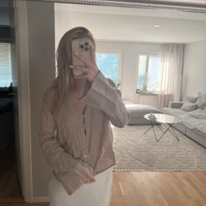 Beige linneskjorta/blus från Zara - Säljer en beige linneskjorta/blus från Zara i linne med v-ringning och knappar framtill. Långa ärmar med lite vidare avslut och en avslappnad passform. Endast använd 1 gång 🌸