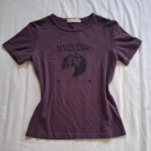 Lila t-shirt med Mazzy Star-tryck - Cool lila t-shirt med tryck av bandet Mazzy Star på framsidan. T-shirten har en rund hals och korta ärmar, perfekt för en avslappnad stil. Materialet är mjukt och bekvämt. Som ny ♡