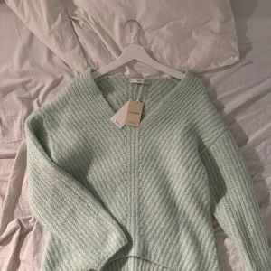 Mintgrön stickad tröja från MNG - Säljer en superfin mintgrön stickad tröja från MNG. Den har en v-ringad design och är perfekt för kyligare dagar. Tröjan är gjord av återvunnen polyester och är en del av MNG:s hållbara kollektion. Passar perfekt för en mysig och stilren look. 💚nypris 499