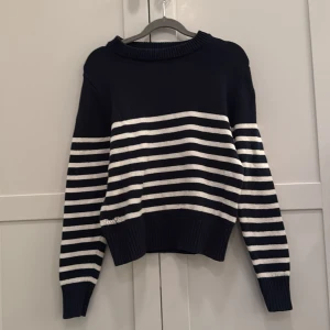 Randig tröja från Zadig & Voltaire - Snygg marinblå och vit randig tröja från Zadig & Voltaire. Tröjan har långa ärmar och knappar på axeln för en extra detalj. På baksidan av tröjan är det vingar 🪽