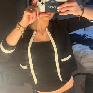 Svart kofta med vita detaljer från Frk - Snygg svart kavaj/kofta från Frk med vita detaljer längs kanterna och vid ärmsluten. Kavajen har en öppen design utan knappar och två fickor där fram. Pris kan diskuteras ❤️